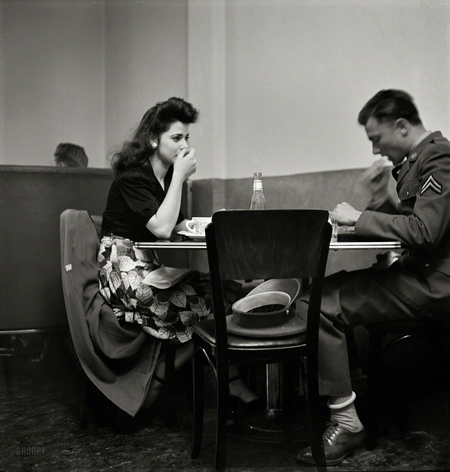 May 1942. "A corporal in the Army takes his girl to dinner. Bakersfield, California." Photo by Russell Lee, Office of War Information. View full size.