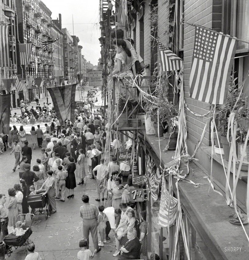 August 1942. New York. "Dancing and music on Mott Street at a flag raising ceremony in honor of neighborhood Italian boys in the Army." Medium-format negative by Marjory Collins for the Office of War Information. View full size.
