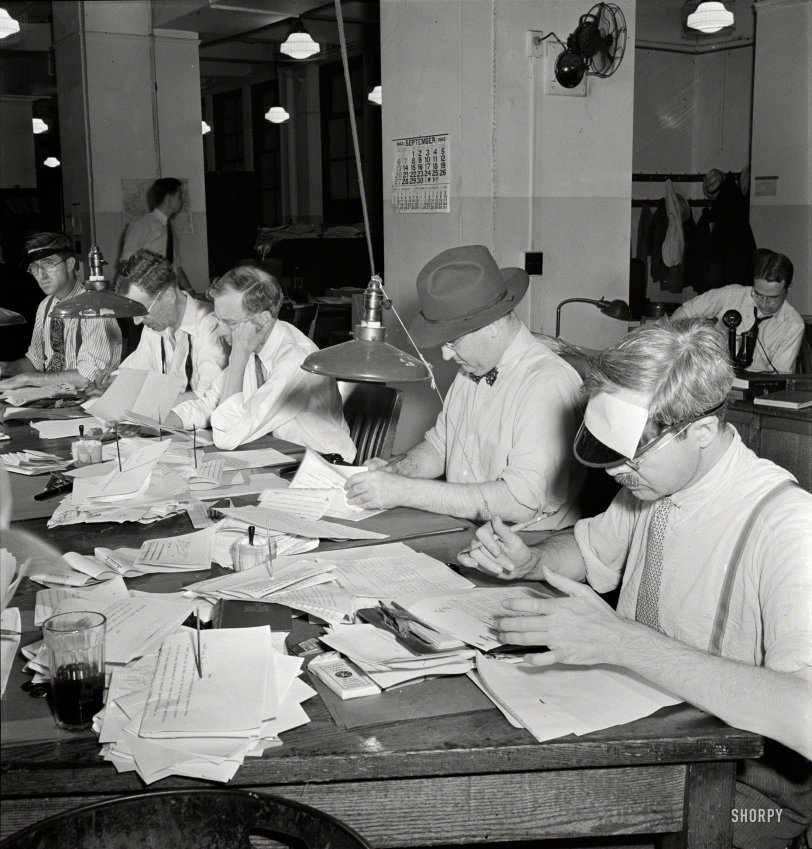 September 1942. Continuing our backstage tour of the New York Times. "Newsroom. Copy readers at the telegraph desk, which handles all dispatches from the U.S. outside New York City. Man wears hat because of draught." Photo by Marjory Collins for the Office of War Information. View full size.
