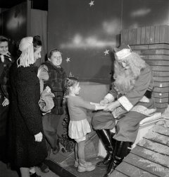 December 1942. "New York. R.H. Macy & Company department store the week before Christmas. Children line up to talk with Santa Claus. There are two Santas, concealed from one another by a labyrinth to prevent disillusionment of the children. Each child is presented with candy and tells Santa his or her desires." Photo by Marjory Collins for the Office of War Information. View full size.