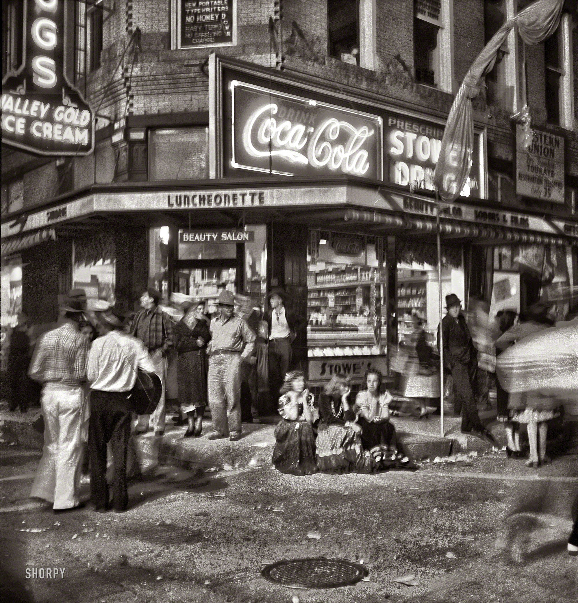 July 1940. "Street scene at the fiesta in Santa Fe, New Mexico." Photo by Russell Lee for the Farm Security Administration. View full size.