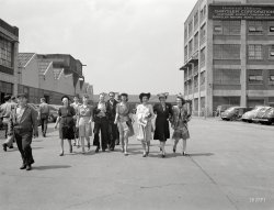 Spring 1942. "Detroit, Michigan. Girls coming out of the Highland Park Chrysler plant." Photo by Arthur Siegel for the Office of War Information. View full size.