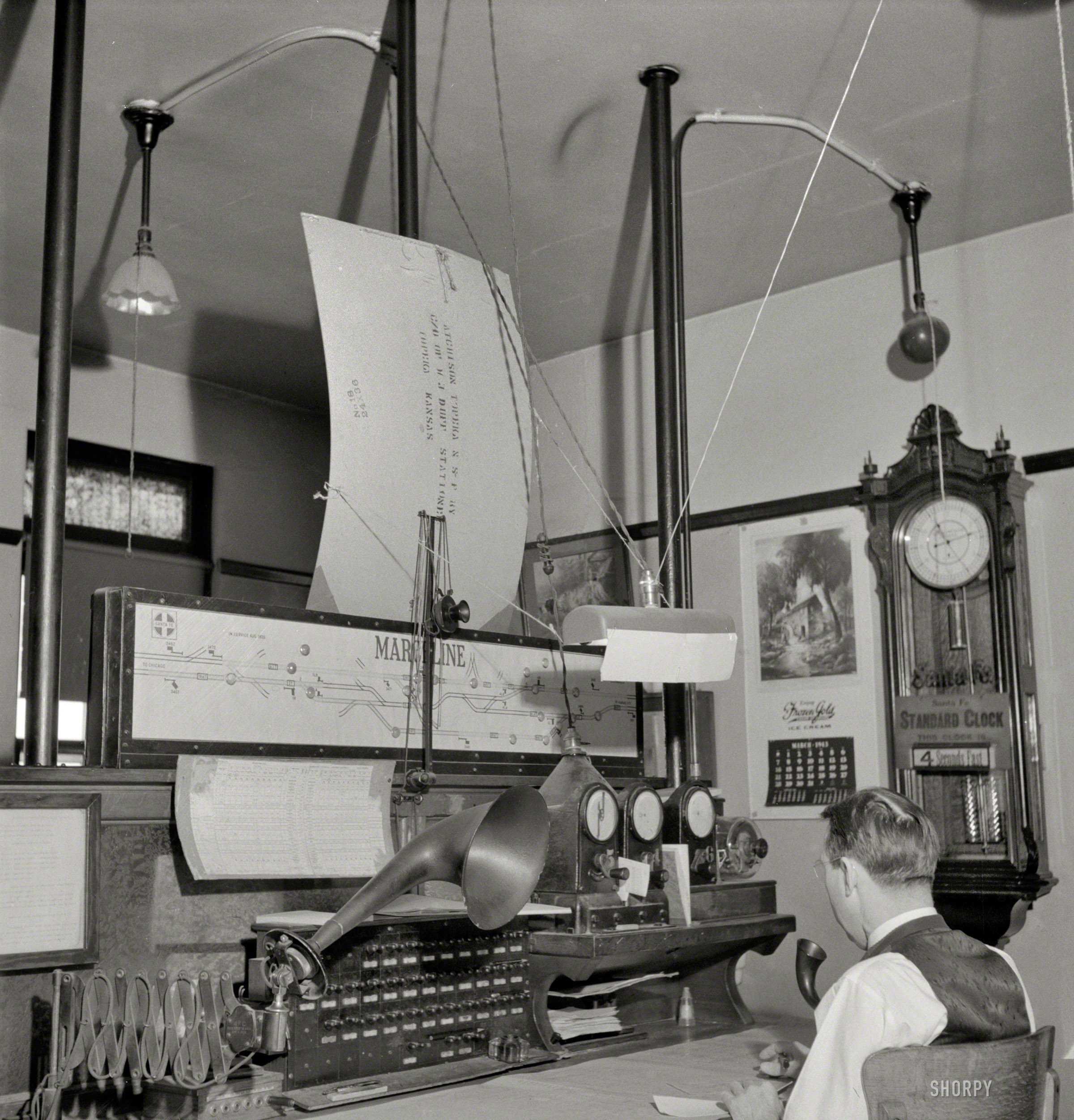 March 1943. More Marceline, Missouri. "A dispatcher at work in the Atchison, Topeka & Santa Fe Railroad offices." This fellow would seem to be sensitive to glare. Photo by Jack Delano for the Office of War Information. View full size.