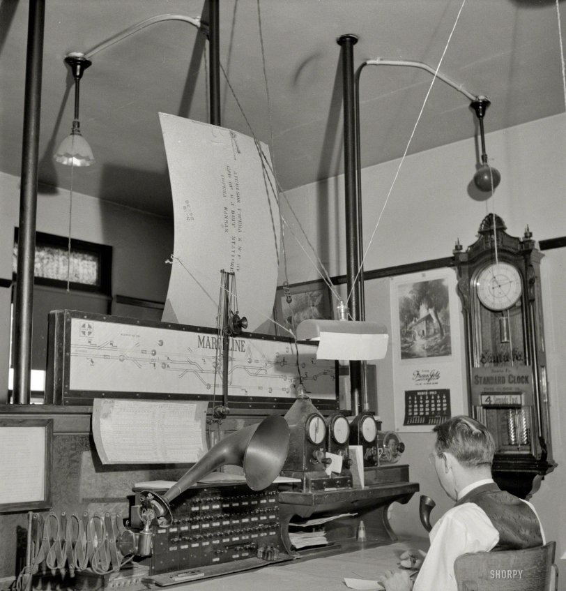 March 1943. More Marceline, Missouri. "A dispatcher at work in the Atchison, Topeka &amp; Santa Fe Railroad offices." This fellow would seem to be sensitive to glare. Photo by Jack Delano for the Office of War Information. View full size.
