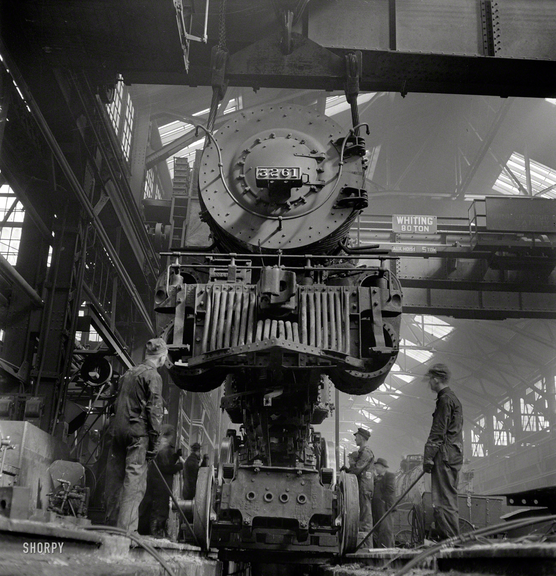 March 1943. "Topeka, Kansas. Wheeling an engine in the Atchison, Topeka & Santa Fe locomotive shops." Photo by Jack Delano. View full size.