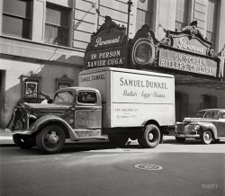 March 1943. "New York. A dairy truck on 44th Street." At the Paramount, a double bill where the distinction between "on screen" and "in person" matters, especially if you're Xavier Cugat. Photo by John Vachon. View full size.
Right in the districtIt's not surprising that Dunkel's butter, egg and cheese business was located at 345 Greenwich Street, as that Tribeca address is in the heart of the old butter, egg and cheese wholesaling district.  These products were known as "staples," a usage which lives on in a short street called Staple Street right around the corner from 345 Greenwich.  At its peak in the 1930's the district was home to over 100 wholesale businesses with thousands of employees.  It began to decline in the 1950's, though the last few wholesalers held on until the 1990's. 
Cuchi-cuchi!For those of a certain age, if you don't know what that means...you weren't really there!
I'm embarrassed to admit that I've seen "Hitler's Children."  The star of this 1943 anti-Nazi gem is Bonita Granville, who later went on to produce the "Lassie" TV show.  As a tiny one, I spent many a Sunday evening negotiating with my Dad over whose turn it was to watch "Maverick" or "Lassie," as they came on at the same time.  I usually won.
Xavier CugatThat must have been a step down from the Waldorf-Astoria.
That&#039;s the side entrance of the ParamountParamount's main entrance was in the heart of Times Square on Broadway at the corner of W. 43rd Street.  Opened in November 1926, it became one of the most famous theatres in the US. Xavier Cugat was in good company playing there.  Benny Goodman, Tommy Dorsey, Harry James, Eddy Duchin, Glenn Miller and Guy Lombardo all performed there at the height of their careers.  Frank Sinatra, the Andrews Sisters and the Ink Spots sang there.
The 3,664-seat Paramount was originally owned by William Fox and contained one of the largest pipe organs the Rudolph Wurlitzer Company of North Tonawanda, NY, ever built.  It contained 36 sets of pipes and weighed in at around 33 tons.  It still exists in the Century II Center in Wichita, Kansas.
The Paramount closed in 1966.  The interior space was remodeled to accommodate various businesses.  One of them, the Hard Rock Cafe, still uses the Paramount's massive marquee.
Samuel Dunkel &amp; Co.Samuel Dunkel &amp; Co. and Sondra Egg Products Corp. were found guilty in 1943 of “conspiring to defraud the United States of approximately $650,000 by delivering under contracts with Federal Surplus Commodities Corporation about 650,000 pounds of rejected egg powder and falsely representing that it had been tested and found to comply with the terms and conditions of the contracts.”  They were also convicted of conspiring “to defraud the United States by obtaining the payment of certain false claims.”  The sentences included fines and jail time.
Slight CorrectionThe small marquee in the photograph was actually located on the north side of West 43rd Street just west of Seventh Avenue, not 44th Street.  The stage door and the loading entrance was located on the south side West 44th Street, just west of Seventh Avenue 
The Hard Rock marquee is a repro, the original having been destroyed when the building was converted to offices in the mid 60's. Not too shabby for a repro.
Special Added AttractionMy most vivid recollection of the Paramount Theatre was back in the early 1950s,  they were showing the film "The Lemon Drop Kid". I was there with a few friends  just killing time before cruising the Times Square area later that night looking for whatever. After the movie ended, the mighty organ could be heard as the stage rose up from its pit. I sort of remember Johnny Long as the band leader. An announcer introduced a special guest, Bob Hope. He was there to promote the film and he read the monologue that he would use on his radio show that week. It was better than the movie.
I guess Mr. Dunkelwas a real butter and egg man!
Finally, one of mine!That's a 1941 Dodge Luxury Liner peeking out behind the truck, probably a coupe, with the uncommon factory turn signals and fog lights, plus a radio. It's a very fine, if somewhat mundane, car. Its flathead Six and Fluid-Drive transmission offer smooth, quiet, and may I say, leisurely, performance.
Let&#039;s RockIn 1958, my friend Billy and I took the subway into Times Square. We saw The Allen Freed Rock and Roll show at the Paramont (it also was at the Brooklyn Fox). The show had a whose who of headliners at the time. His co-host was Murry the K (Kaufman). What a great time.
Paramount marquee restoration...was paid for by the World Wrestling Federation of all things. They had their restaurant there for a few years before moving out. Really good burgers and lots of rasslin' merchandise if you were into that sort of thing.
(The Gallery, Cars, Trucks, Buses, John Vachon, Movies, NYC)