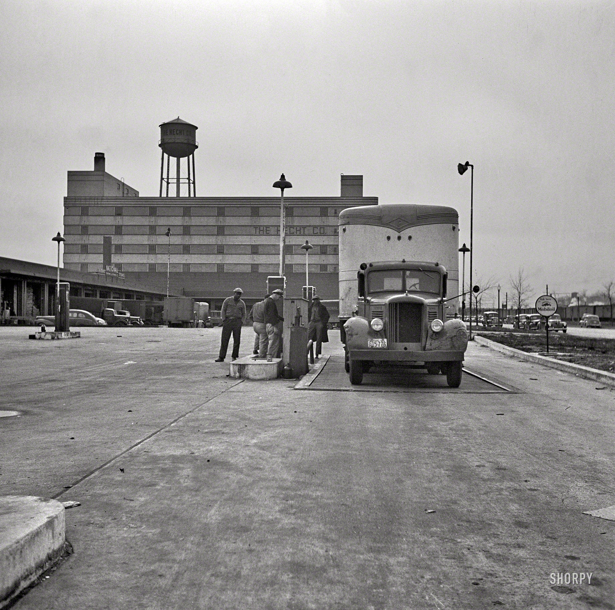 March 1943. "Transport refueling at Hecht Co. warehouse on New York Avenue in Washington, D.C." As opposed to Washington Street in New York, the venue of the previous post, also shot by John Vachon for the OWI. View full size.