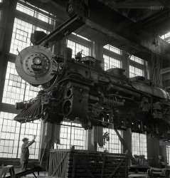 March 1943. Albuquerque, New Mexico. "Lifting an engine to be carried to another part of the Atchison, Topeka &amp; Santa Fe shops for wheeling." Photo by Jack Delano for the Office of War Information. View full size.
Not a Butterfly...It looks like a gigantic Praying Mantis with its small head on a large body turned almost 90º to look at us.
It certainly qualifiesas a "heavier than air" conveyance.
Makes senseSteam does tend to rise.
MonstersWhen I was a little girl way back when, these types of very large behemoths scared me to grabbing my dad's pants leg and hiding behind him shaking like a leaf.  I couldn't get away from them fast enough. ;D  My dad was a diesel mechanic the majority of his working life and he worked on some pretty big machinery.  It always scared me silly.  Looking at these pictures still has a bit of that effect on me.  It's almost as if it has turned it's head to look at me and say "BOO!!!"  I hope the train never fell on anyone.
22 years down, 12 to goBy the number, this is a 4-8-2 "Mountain", built by Baldwin in 1921.  If it was all there, it would weigh over 352,000 pounds! After this rebuild, 3733 went on to hit a "Caterpillar shovel" in 1945.  It was scrapped in 1955.
(The Gallery, Jack Delano, Railroads)