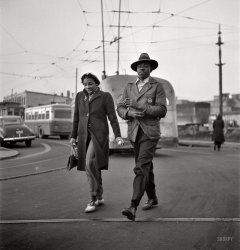April 1943. Baltimore, Maryland. "Workers hurrying to catch a conveyance for their jobs at 7 a.m." Style notes include the brooch and hat. Medium format nitrate negative by Marjory Collins for the Office of War Information. View full size.