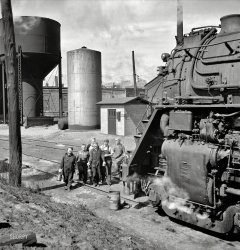 May 1943. Clinton, Iowa. "Women wipers of the Chicago &amp; North Western Railroad going out to work on an engine at the roundhouse." Medium-format negative by Jack Delano for the Office of War Information. View full size.
PerspectiveThis really gives the viewer an idea of just how monstrously big that engine was!
TerrificJust terrific!
More Big Boys!As this shows up while Union Pacific 4014 is in transit to Cheyenne Wyoming for restoration, it would be nice to see more photos of the Big Boys in their heyday - and more of the Women Wipers too!
[Click the link in the caption. - Dave]
Not to diminish the size... of a steam locomotive, but the women are farther away from the front of the locomotive than it seems; a man standing beside that steam cylinder would almost be as tall as the cylinder. Steam locomotives were large indeed.
(The Gallery, Jack Delano, Railroads)