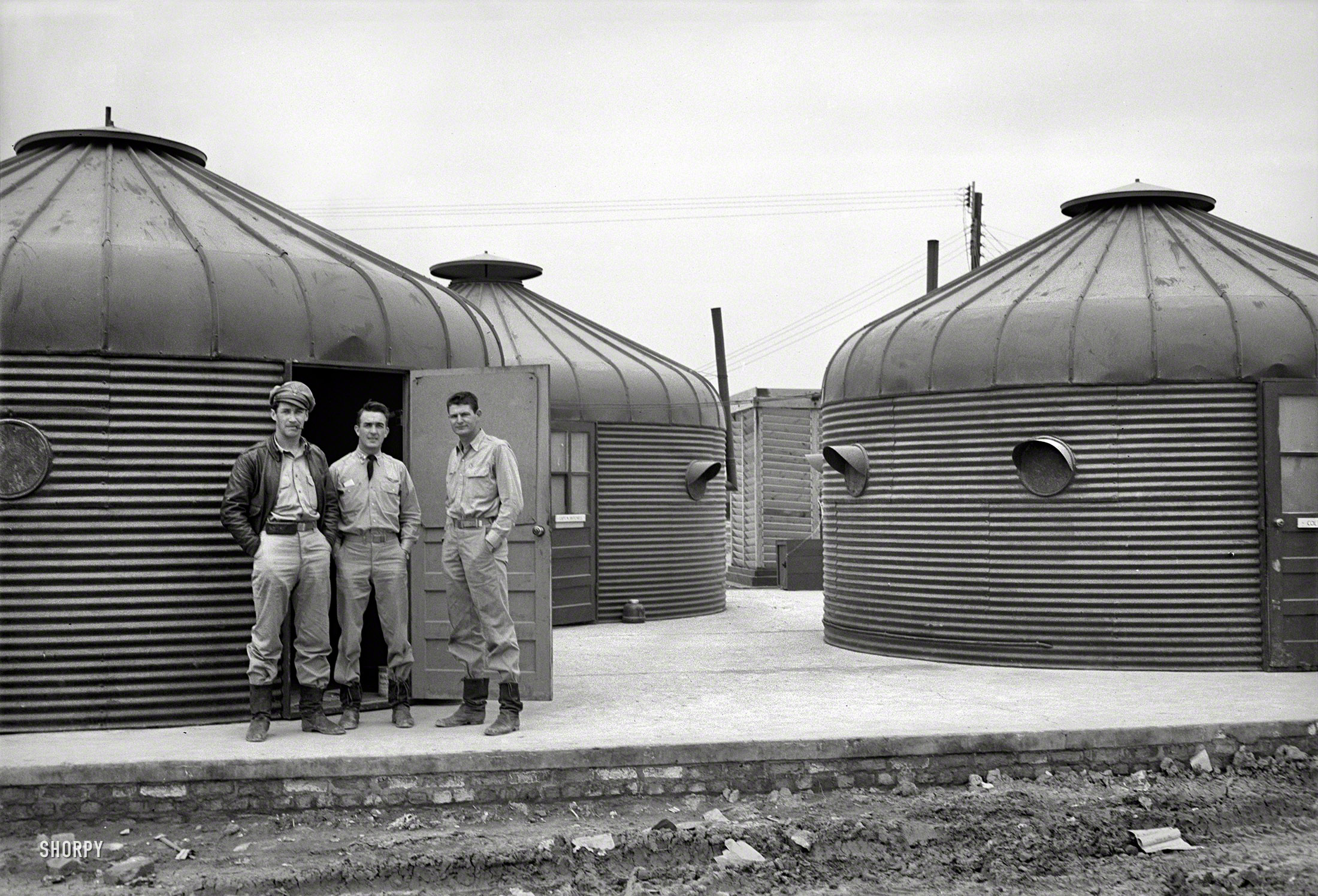 From around 1943 comes this uncaptioned photo, somewhere in North Africa, of Dymax&shy;ion Deployment Units. The prefab huts, used here as officers' quarters, were based on Buckminster Fuller's Dymaxion House, "metal adapted corn bin, built by Butler Brothers, Kansas City." Office of War Information. View full size.