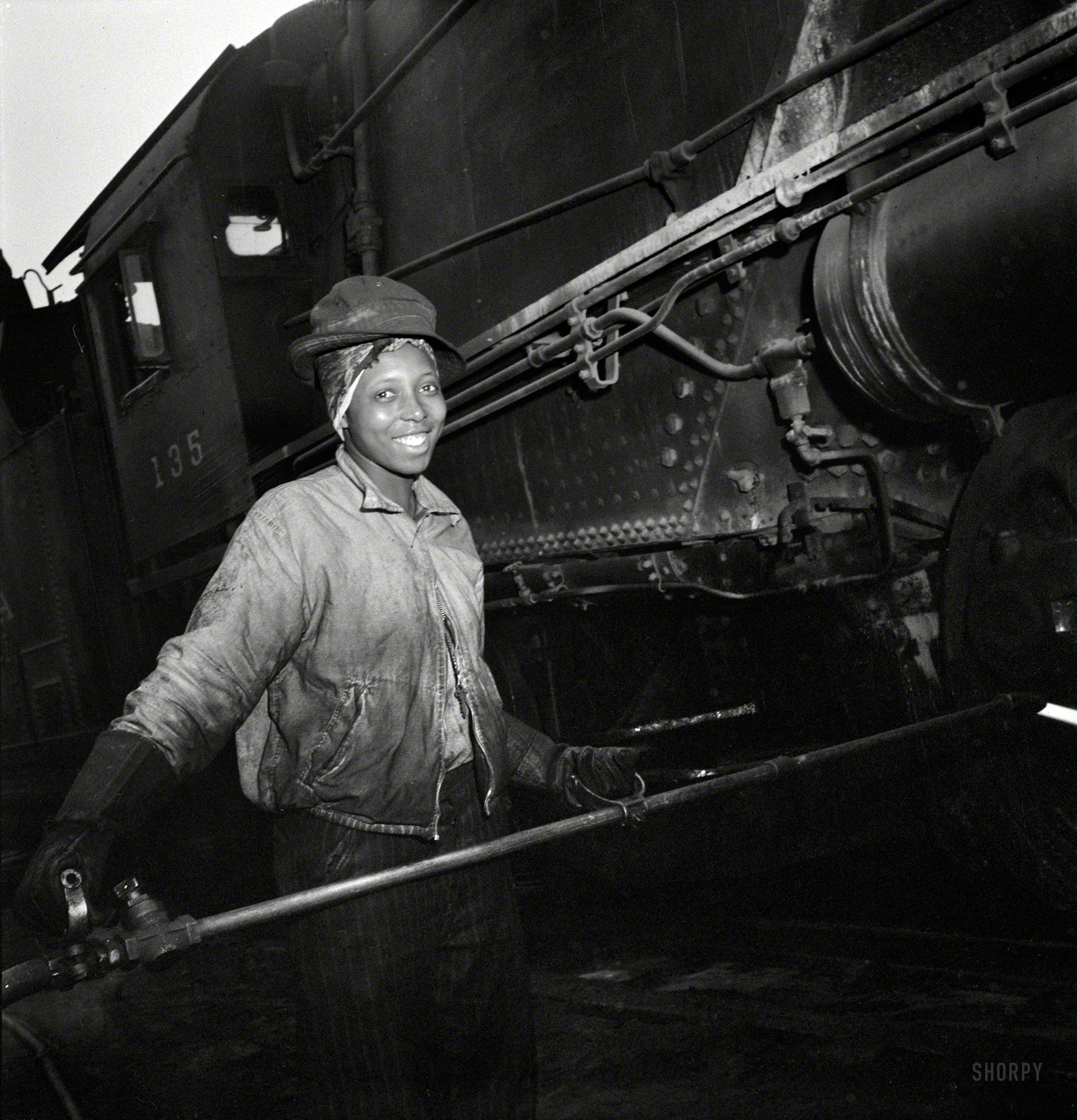 June 1943. "Pitcairn, Pennsylvania. Mrs. Bernice Stevens of Braddock, Pa., mother of one child, employed in the engine house of the Pennsylvania Railroad, earns 58 cents per hour. She is cleaning a locomotive with a high pressure nozzle. Her husband is in the Army." Photo by Marjory Collins. View full size.