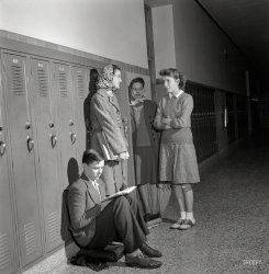 October 1943. Washington, D.C. "Sally Dessez talking with some friends near her locker at Woodrow Wilson High School." Popular girls and their minion. Photo by Esther Bubley for the Office of War Information. View full size.