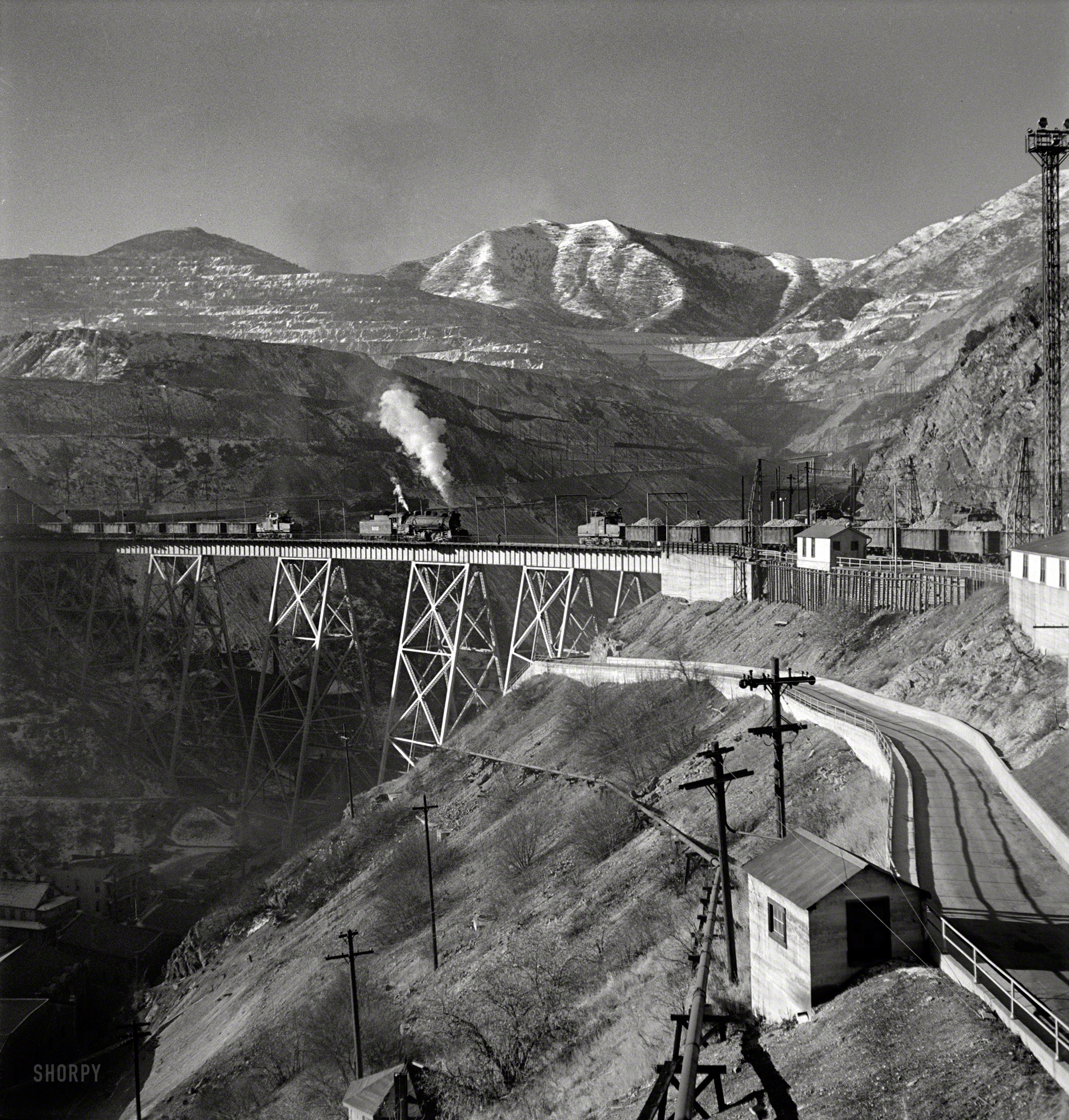 November 1942. "Bingham Canyon, Utah. Ore trains on a trestle bridge above an open-pit mine of the Utah Copper Company." Photo by Andreas Feininger for the Office of War Information. View full size.