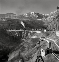 November 1942. "Bingham Canyon, Utah. Ore trains on a trestle bridge above an open-pit mine of the Utah Copper Company." Photo by Andreas Feininger for the Office of War Information. View full size.