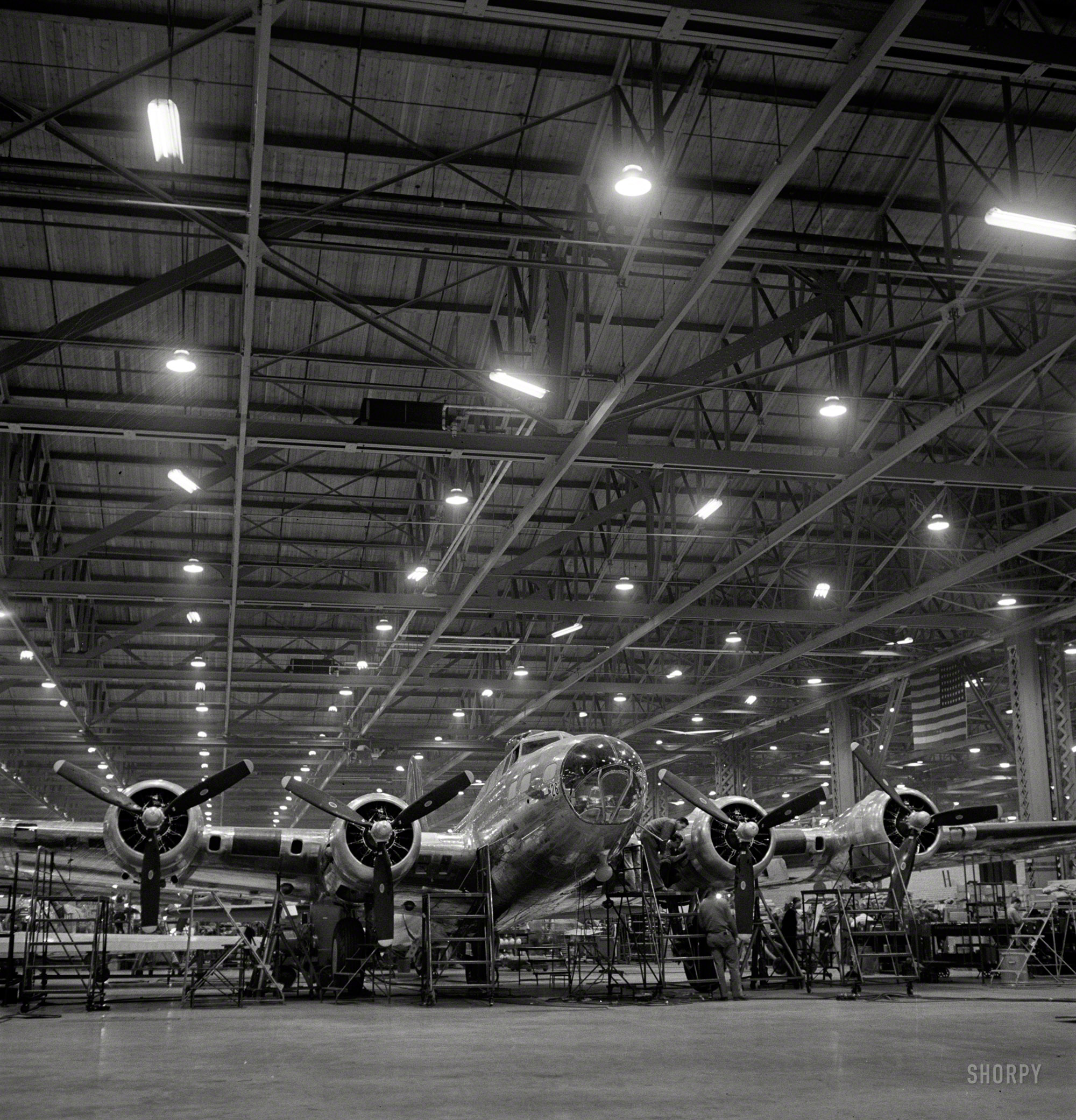 December 1942, a year after Pearl Harbor. "Production. B-17 heavy bomber. A nearly complete B-17F 'Flying Fortress' at Boeing's Seattle plant." Photo by Andreas Feininger for the Office of War Information. View full size.