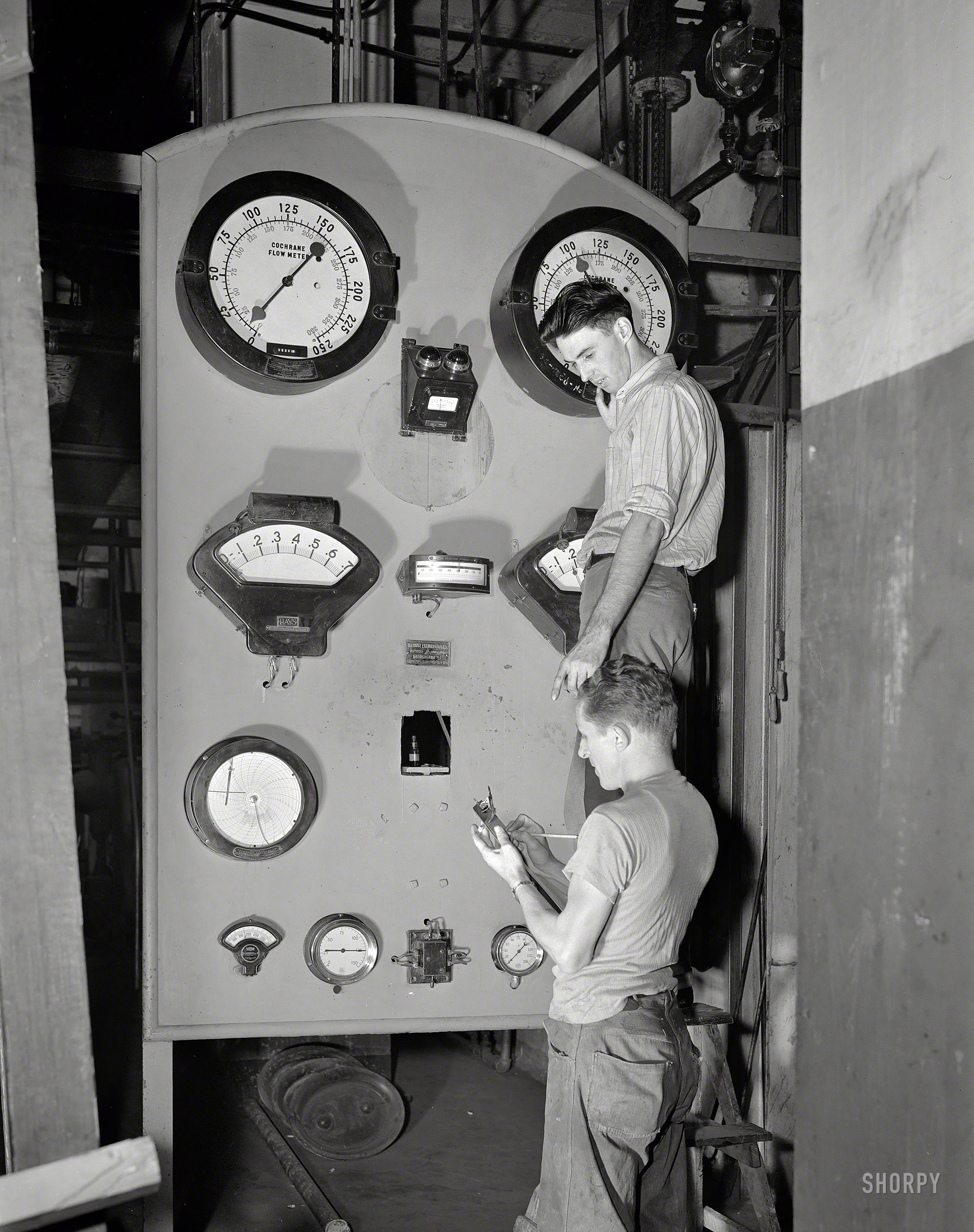 September 1942. "Washington, D.C. Conversion of the Shoreham Hotel furnace from oil to coal burning system." Crank it, boys, and let's see what this thing'll do. Photo by Howard Liberman for the Office of War Information. View full size.
