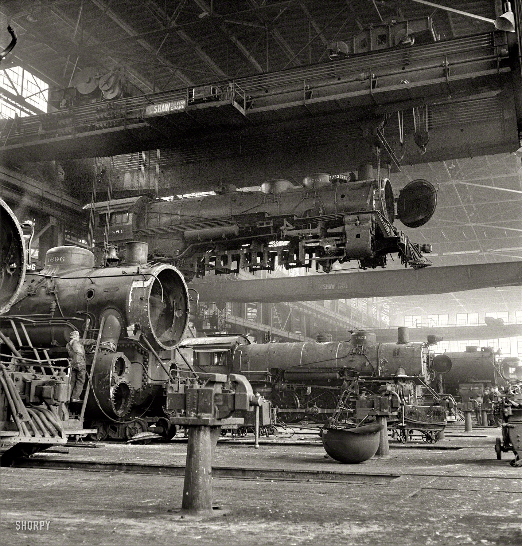 March 1943. Albuquerque, New Mexico. "An engine being carried to another part of the Atchison, Topeka & Santa Fe railroad shops to be wheeled." Photo by Jack Delano for the Office of War Information. View full size.