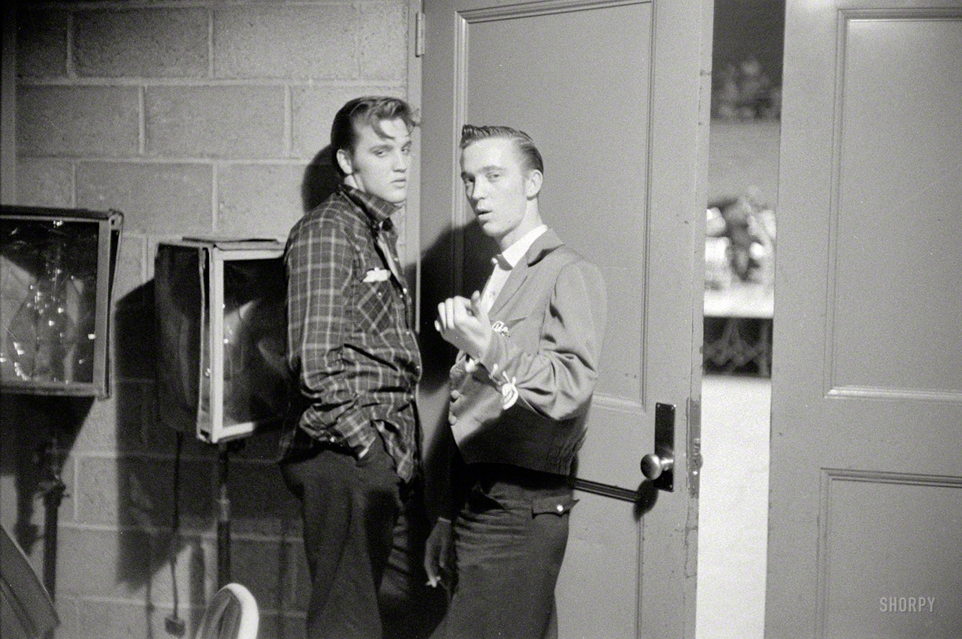 May 27, 1956. Dayton, Ohio. Elvis Presley with his cousin Gene Smith backstage at the University of Dayton field house, on the threshold of superstardom. 35mm negative by Phillip Harrington for Look magazine. View full size.