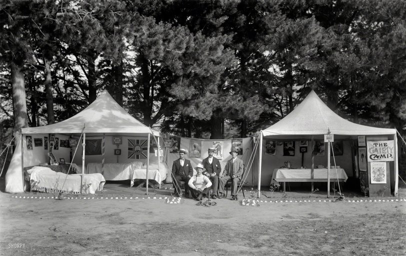No slapdash campsite for these circa 1910 New Zealand outdoorsmen: "Unidentified men sitting between two open tents with beds, tables, pictures, flags and posters on the walls, and Gaiety Camp sign, quoits game in front, pine trees behind. Sumner, Christchurch." Glass negative by Adam Maclay. View full size.

