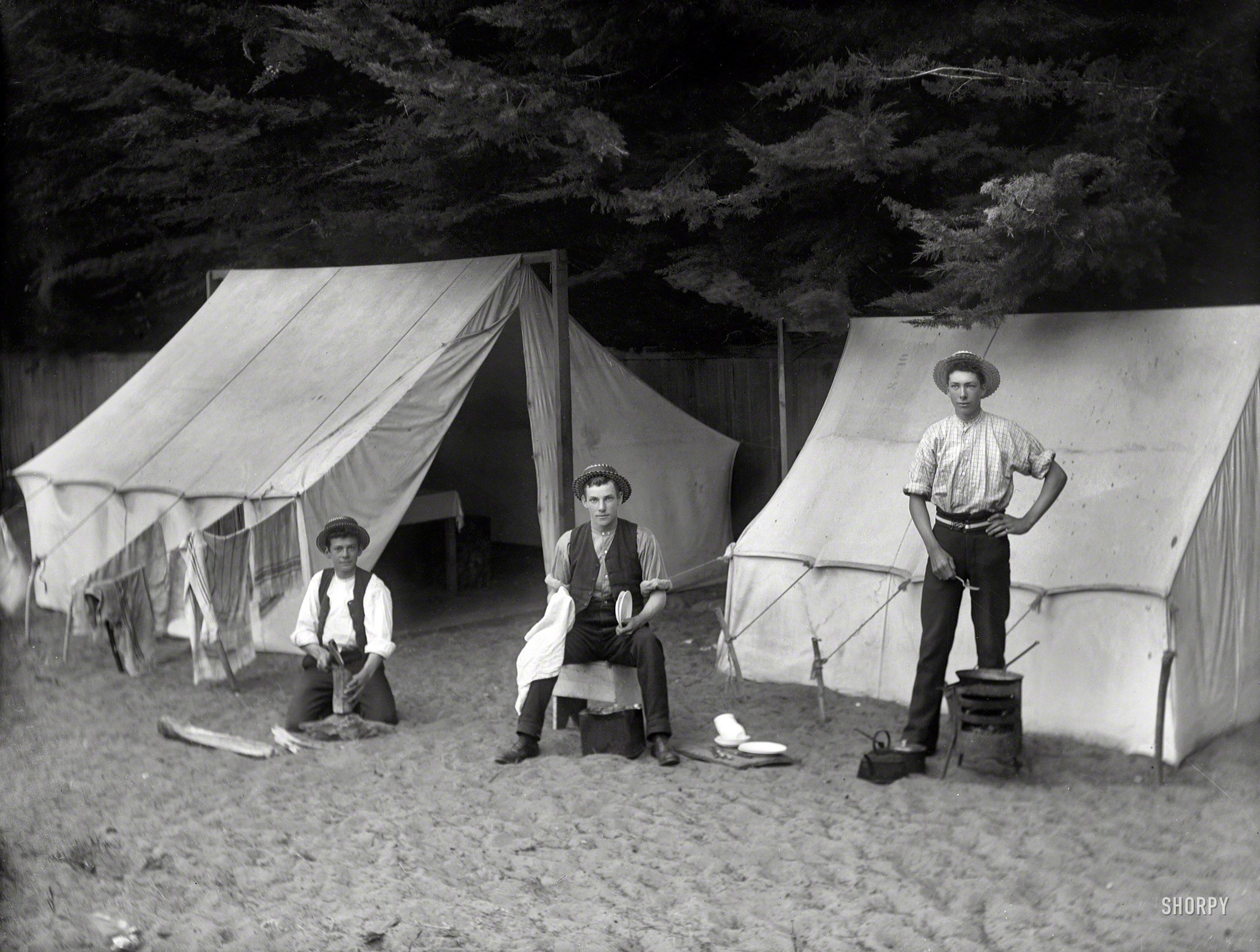 &nbsp; &nbsp; &nbsp; &nbsp; "We are decent lads and would be delighted to have your sister or daughter to tea."
New Zealand circa 1902. "Three men at campsite doing odd jobs, showing one man chopping wood, one man doing dishes and the other man cooking, possibly Christchurch district." Glass negative by Adam Maclay. View full size.