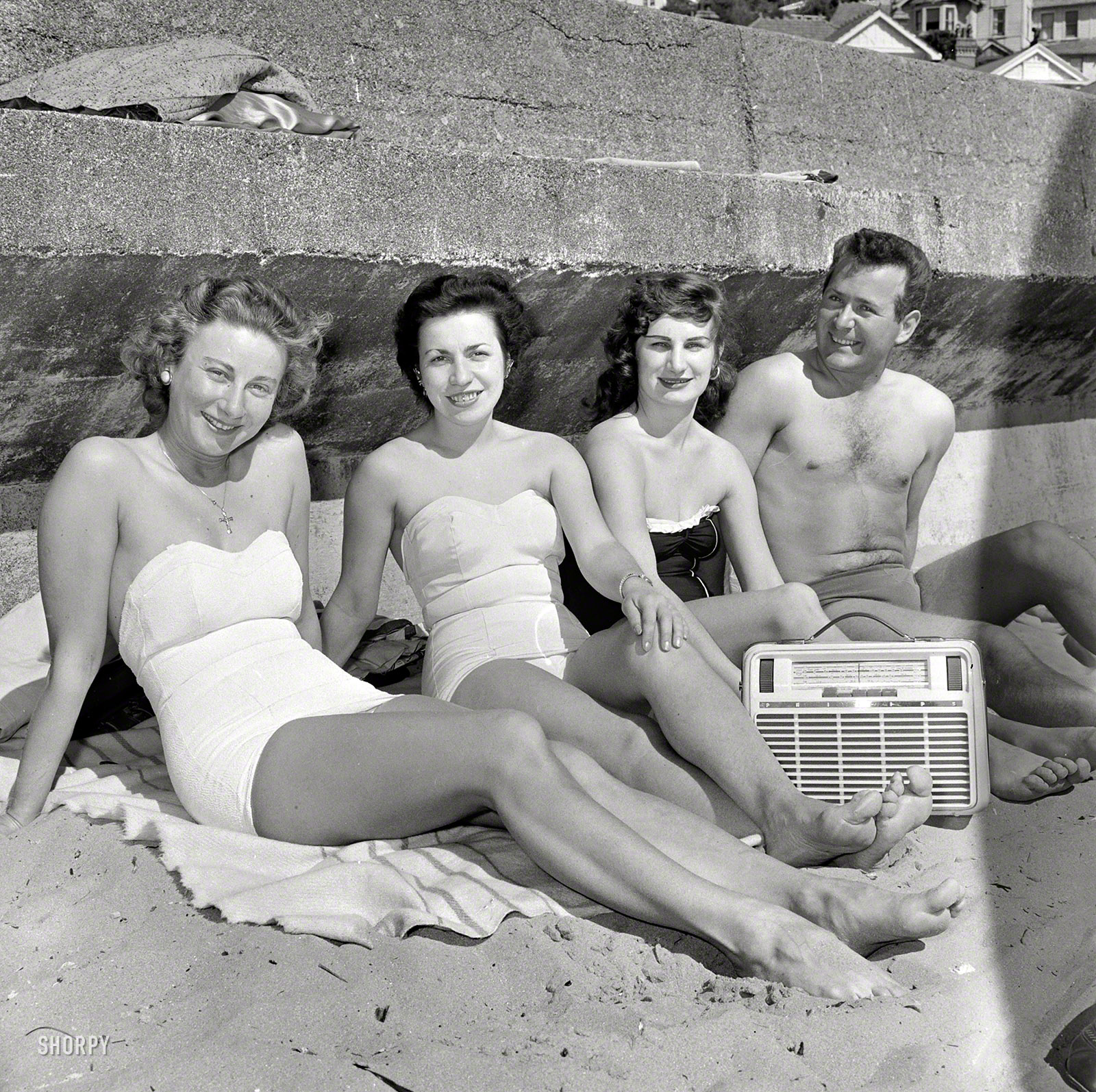1958. "Swimmers listening to radio and relaxing at Oriental Bay Beach, Wellington, New Zealand." Evening Post photo archive. View full size.