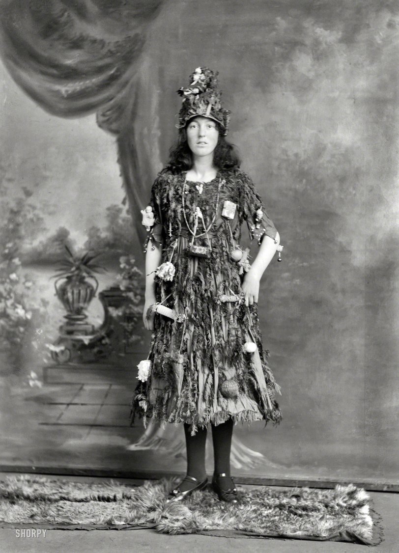 New Zealand circa 1910. "Studio portrait, young woman in Christmas tree fancy dress and hat costume, with little presents and decorations hanging off her, Christchurch." Half-plate glass negative by Adam Maclay. View full size.
