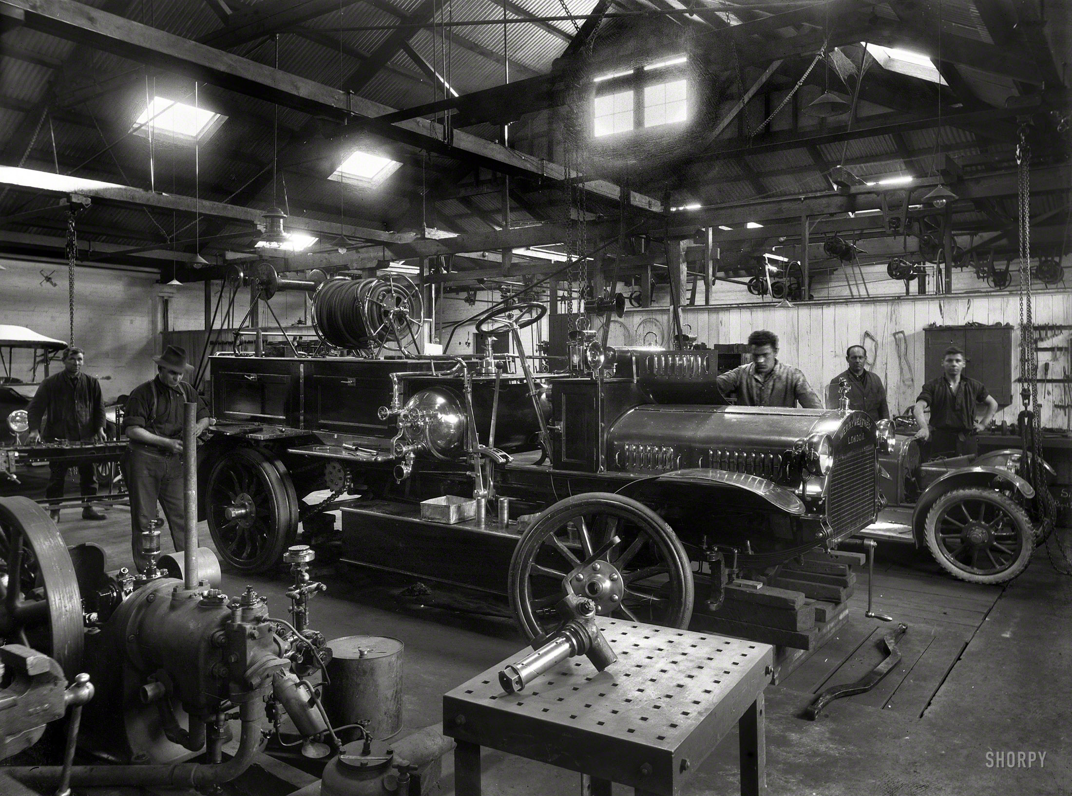 New Zealand circa 1921. "Wanganui Fire Brigade's Merryweather fire engine on blocks, probably in Chavannes Garage. When new, the vehicle had a large hose reel, later removed and replaced by rear lockers. A report in January 1926 stated that the machine was useless and unreliable. It was sold a short time later for 60 pounds." Glass negative by Frank J. Denton. View full size.