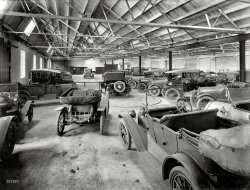 Circa 1917. "Motor cars in New Zealand Farmers Co-Op Garage." Glass plate by Samuel Heath Head, Christchurch. View full size.
Do you recognize?Any De Dion Boutons, Silent Sunbeams, 10-horsepower Austins, Siddeley-Deasys, Noiseless Napiers, American Mitchells, Maxwells or Buicks? 
That &quot;coffin nosed&quot; caris most like a Renault.The only other car with a cowl like that was a Franklin but I don't believe a Franklin would have had delicately spoked wire wheels like this car wears.
The second car from the rightI'm really curious to know what make that coffin-nosed auto is.
Calling all car nuts!
RoundhouseIt seems the parking in tight quarters is aided by the two (at least) large discs embedded into the floor.
[Turntables. - Dave]
&quot;Coffin Nose&quot;The car in question appears on Manalto's list- it would have to be a Siddley-Deasey. Two cars beyond that is a nice Hupmobile.
OverallA very high-end looking group.  Apparently, there was good money in sheep circa 1917.
Before ABSThe vehicle in the near center foreground sports a 'NonSkid' brand tire on the left front. On the left rear is a 'MaySkid' tire.
Hupps-a-plentyHupmobile exported a fair number of cars to New Zealand; I believe there may be as many as four Hupmobiles in this photo.  The one previously identified by Roverdriver (two down from the Siddeley-Deasy) is a 1912-1915 Hupmobile Model 32.  The neighboring car beyond that is also a Hupp: a 1916 Model N.   In the front left foreground, the two small runabouts with matching fenders are 1910-1912 Hupp Model 20's, the first model produced by Hupmobile.  On the left runabout, it looks like the missing tire from the front right wheel is resting in the back seat of the car.
DefinitelySiddeley-Deasy.  A 18-24hp from 1913 is shown below. 
(The Gallery, Cars, Trucks, Buses, New Zealand)