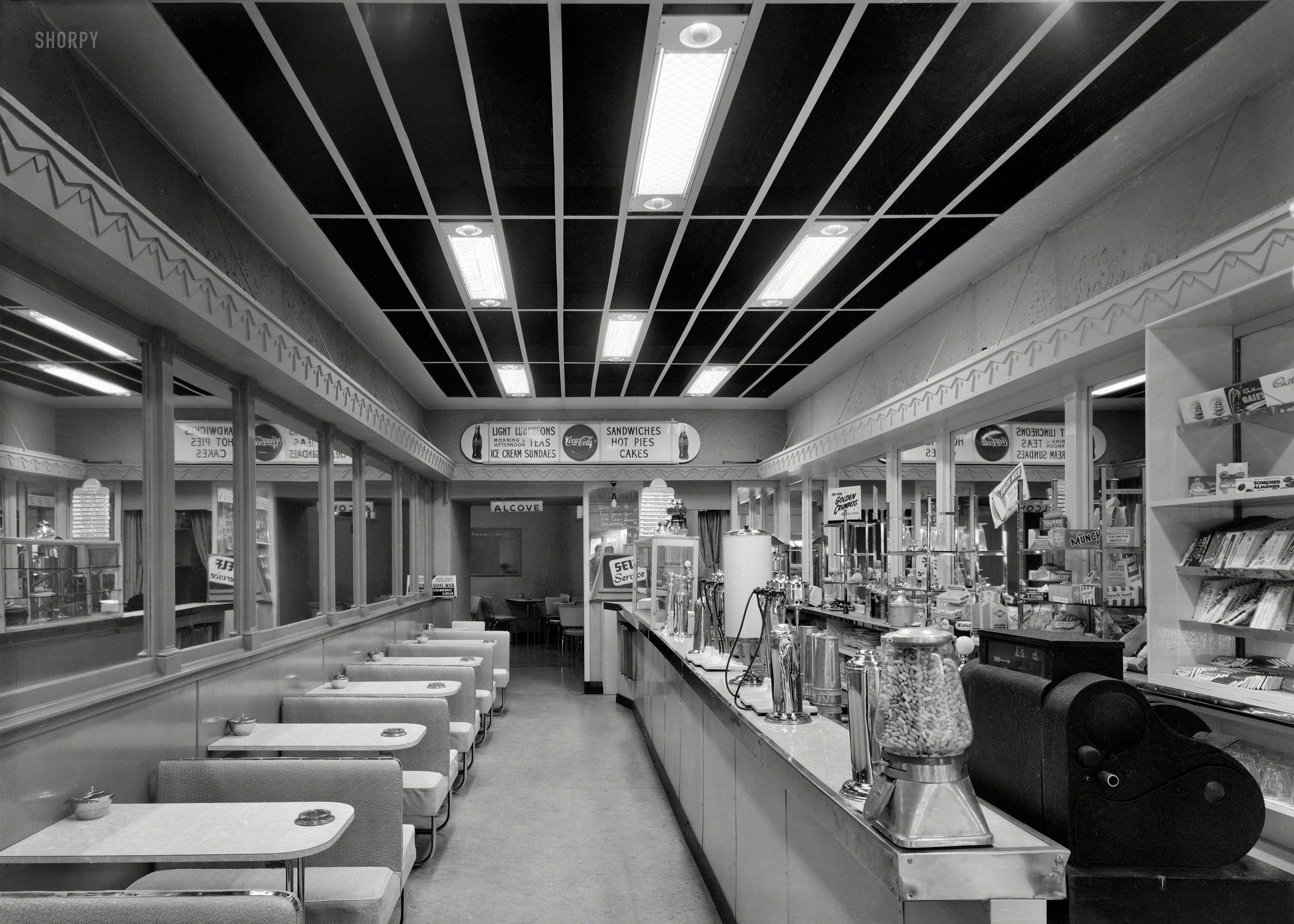 1950s. Wellington, New Zealand. "Interior of Sunshine Milk Bar lined with booths, photographed by K.E. Niven & Co." Large-format acetate negative, K.E. Niven & Co. Collection, Alexander Turnbull Library. View full size.