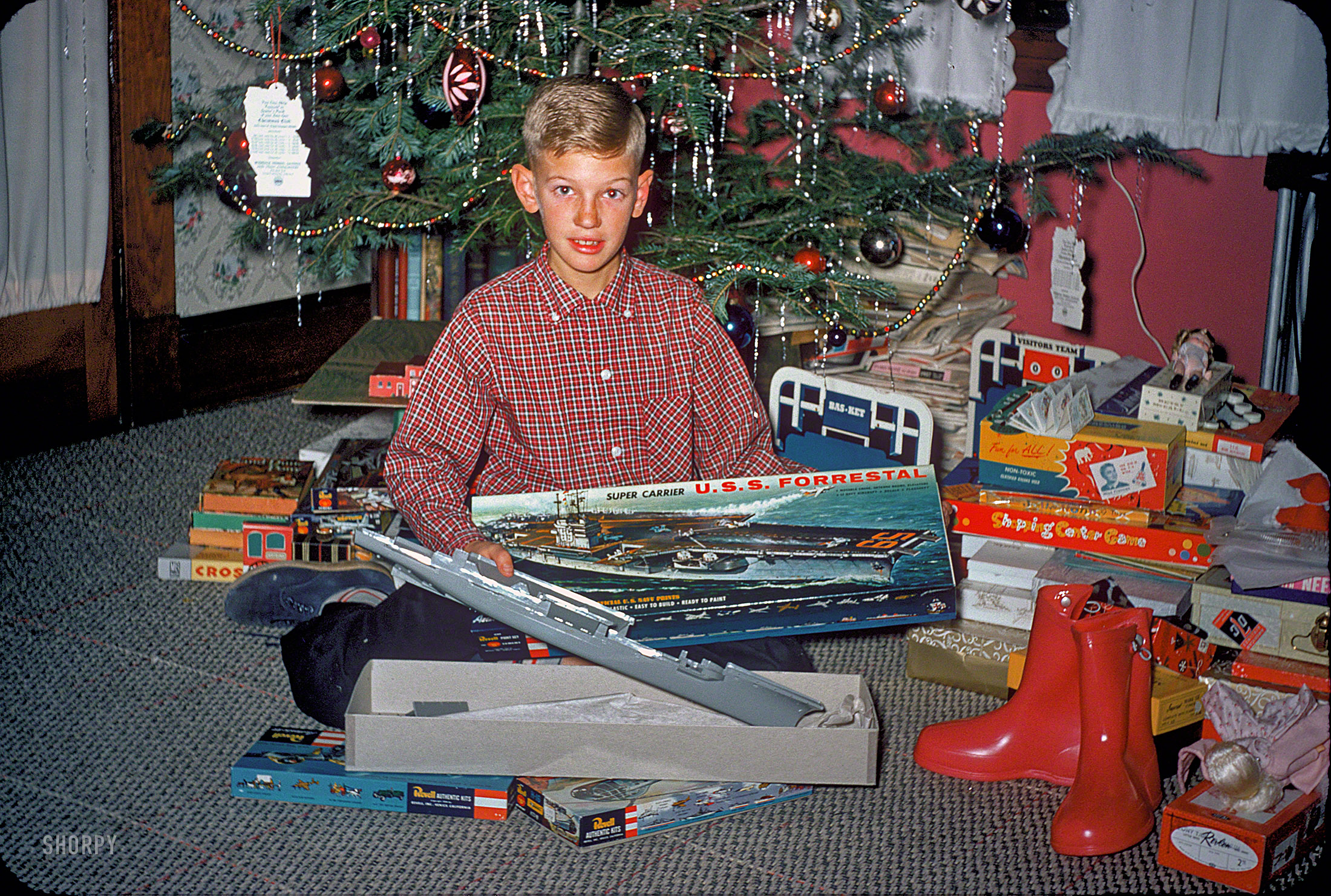 "Christmas 1957" is the label on this slide from the Kermy and Janet Kodachromes, taken at their house in Baltimore. Gifts include a Revell model aircraft carrier and something called the Shopping Center Game. View full size.