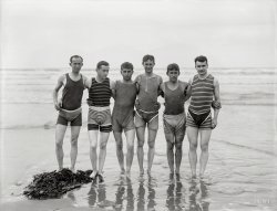 By 1910, men's bathing costumes were sleeveless and cut off at mid-thigh. However, as required by some bylaws, many male bathers, such as this group, wore trunks over their one-piece suits.
-- Encyclopedia of New Zealand
New Zealand circa 1910. "Unidentified bathers, probably at Christchurch." Dry plate glass negative by Steffano Francis Webb. View full size.
Talk about unflatteringThey mostly look like a combination of diapers pulled over striped rags, but I forgive the boys if I can just meet the Grecian god third from the left and lose myself in those beautiful eyes.
One hundred years laterI still see men jogging around town wearing shorts over their sweatpants so I guess everything old is new again.  Does the expression "plum smugglers" ring a bell?
OverwearAs Esposito decrees in "Bananas," "The people must change their underwear every day, and to make sure, they must wear it on the outside." (Or words to that effect -- I don't have the script handy).  For better or worse, this is definitely a Kiwi "look," and prescient, too.
Please --Bring back the freakin' cats.
I seeThere a couple of cool cats right here. Nothing like a little eye candy to go with my morning coffee.
Gentlemencheck your weapons at the door, please. We run a respectable establishment here.
(The Gallery, New Zealand, S.F. Webb, Swimming)