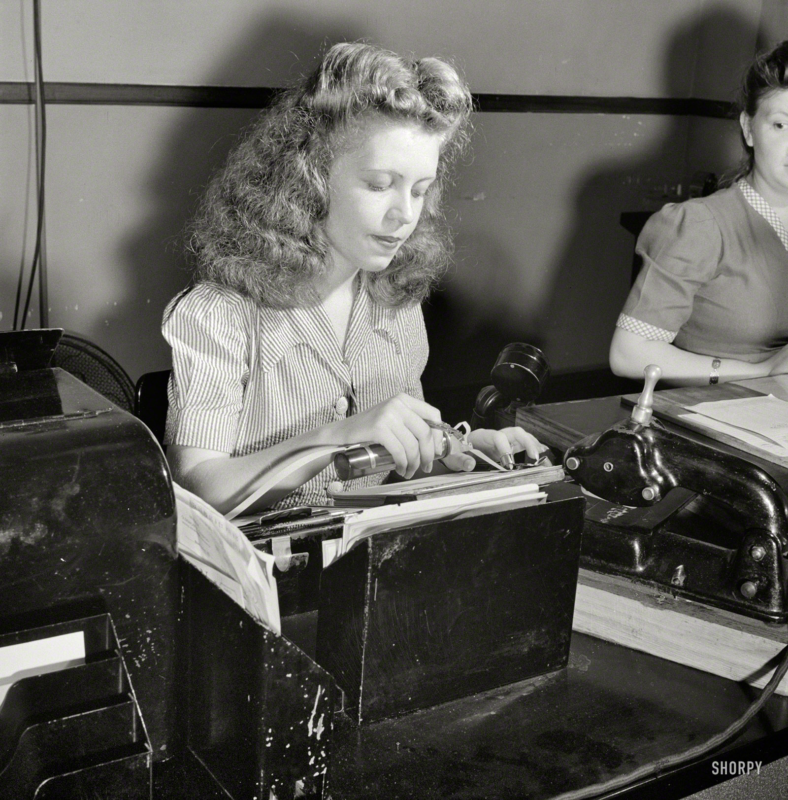 &nbsp; &nbsp; &nbsp; So many of you guessed correctly on this one that we're not going to wait till tomorrow for the answer -- the lady's job is: Telegram gummer. Original caption for the photo, taken by Esther Bubley: "June 1943. Miss Kathleen McCarthy, a Western Union teleprinter operator, gumming telegraph messages."

The year is 1943 and the place is Washington, D.C. What is this girl doing? (Hint: Hundreds if not thousands of people had the same job over the course of many years.) Check back on Sunday for the answer. View full size.