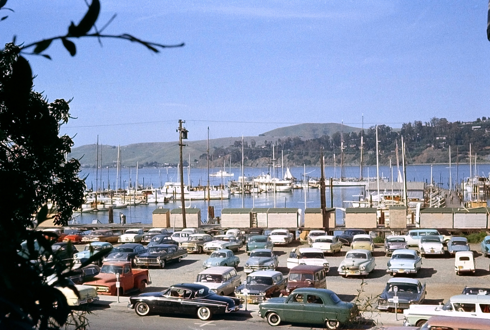 The yacht harbor in Sausalito, California, shot on Anscochrome circa 1958. I believe this is on Richardson Bay, with Belvedere Point in the background. There are some pretty interesting cars in in this shot, including the mysterious little European-looking thing on the far right.  View full size.