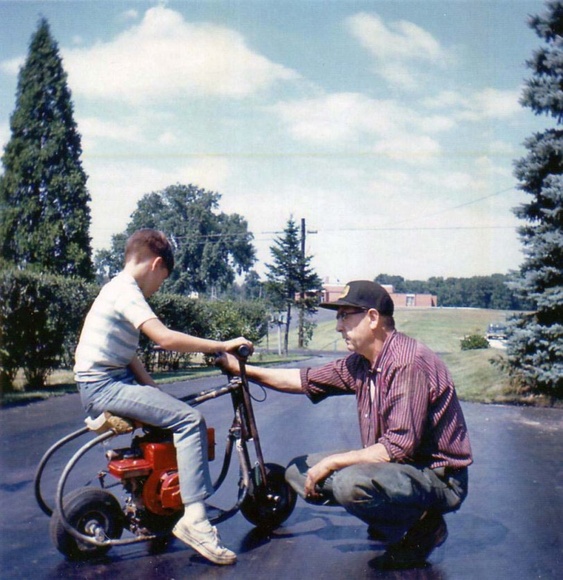 My Grandpa telling me the rules of riding. I think he was telling me not to drip any gasoline on his driveway, but I don't remember for sure. View full size.
