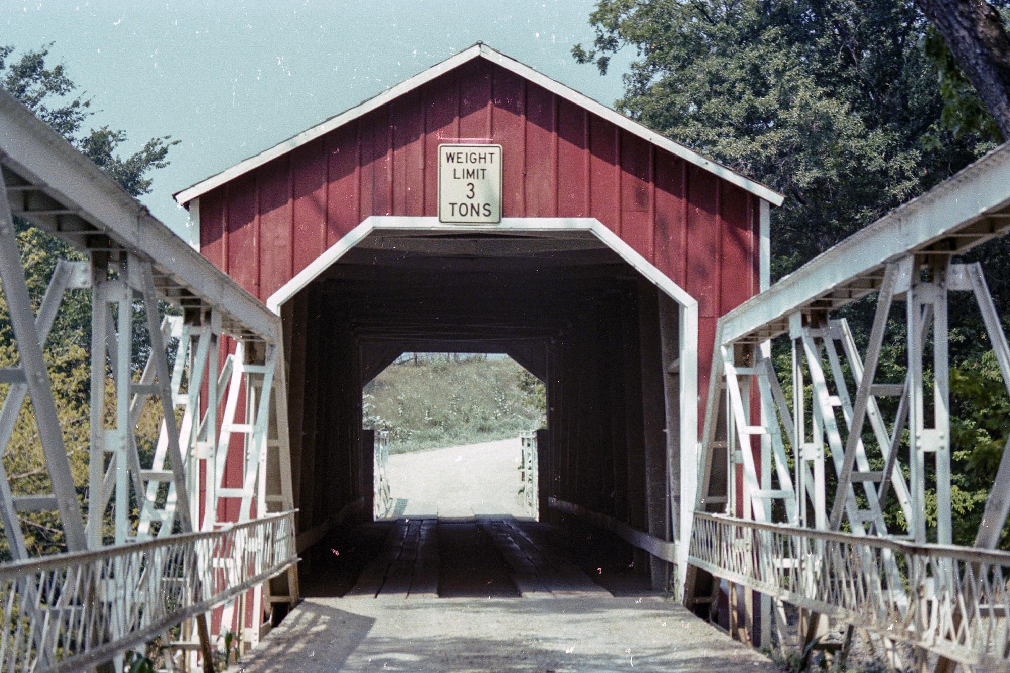 The Wolf Covered Bridge over the Spoon River in Knox County, Illinois, 1979. The bridge was built by cattle rancher Jacob Wolf in 1848. Wolf designed it to resemble an open barn door so that cattle would cross it more willingly and without incident.

James Burkhalter, a former Civil War Captain, built a swinging end-door enclosure a year after a flood in 1873. The enclosure helped to preserve the wood from rot and reinforced the bridge.

The bridge burned on August 1, 1994. Three boys were arrested for arson. After a lengthy trial, the juveniles were found guilty on lesser charges and placed on probation. All were under-age at the time of the fire. A replica was built in 1999 and made wider and taller for modern vehicles.