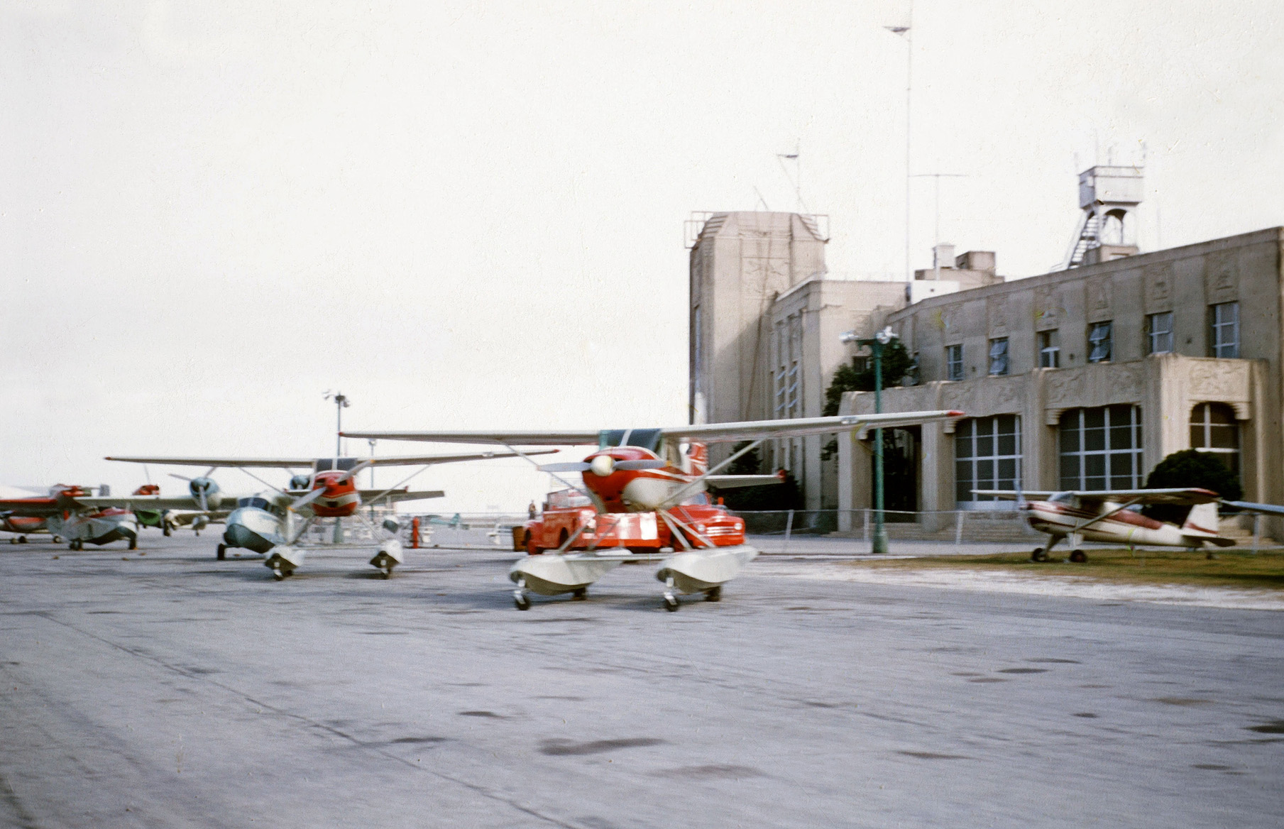 My dad had a new Piper Super Cub fitted with pontoons and this may be where he had it done. This slide would have probably been taken in mid-1957.

Can anyone identify this place? I'd love to know where it is; that's a nice-looking building. I have a couple of other photos taken here but they show planes and probably wouldn't help identify the locale.

I apologize for the terrible focus; I was in the first grade when I took this and was nervous using my dad's camera (Kodak Signet 80, for you camera buffs!). View full size.
