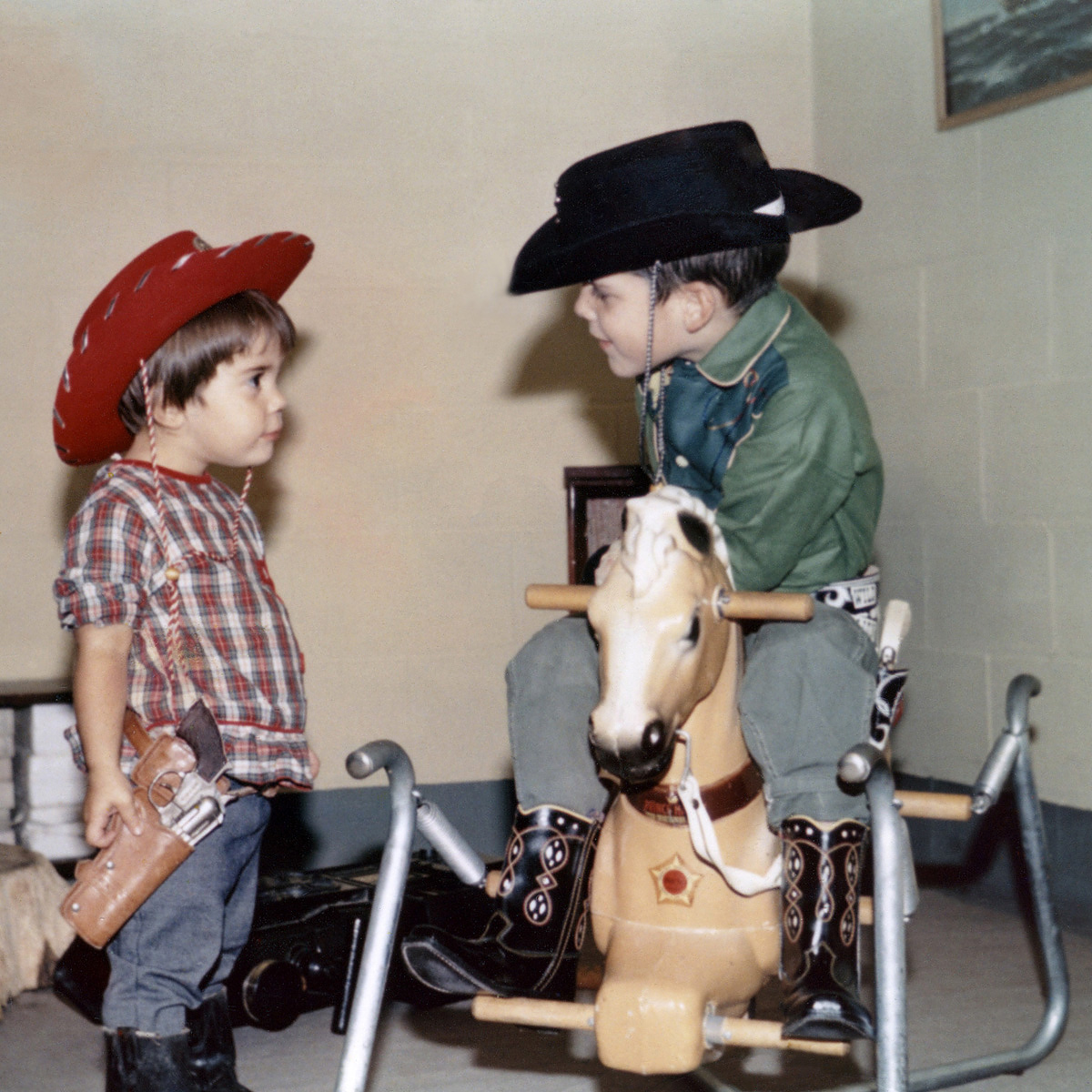My cousins Sue and Dean playing cowboys during 1968 in the basement of their home in West Bend, Wisconsin. I get the impression that when this photo was snapped the subjects were having a discussion as to why Sue couldn’t be the one riding the horse. View full size.