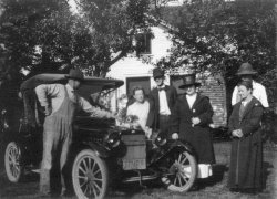 Northern Indiana between 1920 and 1922.  The tall thin man in the middle is my grandfather, Roy Swank.  We're trying to figure out what kind of car this is.  My mom looked online for historical plates in Indiana and decided the license plate is from 1920.
people (left to right) are Jacob Brumbaugh, Kate Schwab Brumbaugh, Roy Swank, Helen Welch Swank (Roy's first wife) Elizabeth Schwab Swank (and sister to Kate). Perhaps behind Elizabeth is Paul Price, who would be Jacob and Kate's son-in-law.
Can anyone tell us what kind of car that is? View full size.
1913-14 SaxonThe car is a 1913 or 1914 Saxon roadster.  In 1915 Saxon switched to electric headlights.  It sold new for $395.
(ShorpyBlog, Member Gallery)