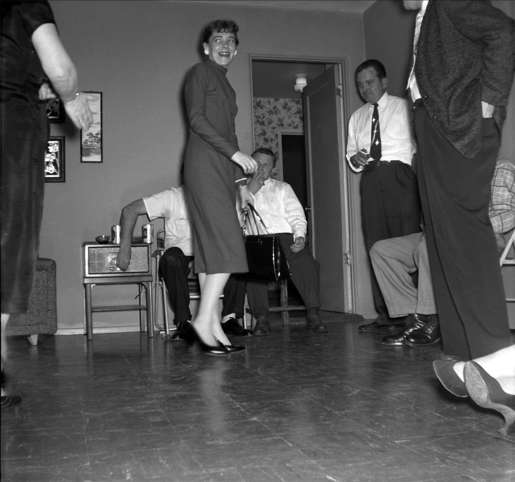 I'm going to guess this is 1956 judging from the packet of negatives it was with that seem to date from that year. I don't know who these people are but at first I thought the lady was going to dance but she's probably leaving due to her holding a purse. Look at the awesome tie the guy in the corner has. Scanned from a Kodak safety negative. View full size.