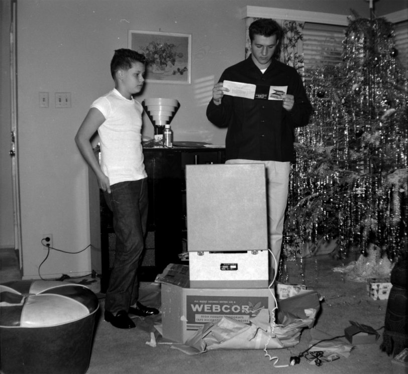 This was taken in Los Angeles, 1956. The present just opened is a Webcor record player. To the left is my great uncle Paul and the right is my grandpa, seen later washing the car with my dad.
I wonder if there's a tree under all that tinsel. Scanned from a Kodak safety negative. View full size.
