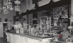 A soda fountain image from the Prohibition era. The Crystal Bar of Virginia City, NV, c. 1927. The gumball machine to the left of the young man behind the counter helps date the photograph. It is a "FAMOUS 1-2-3" Vendor from R.D. Simpson CO, patented 1923. View full size.
