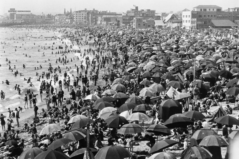 Taken at Venice Beach, Calif. 1920s. The early bird got a place to sit in the sand. View full size.
