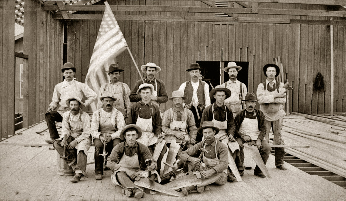 This family photo was taken on July 4th, 1887. My grandfather is seated on the floor at front left. That's his helpful dog next to him holding a hammer in its mouth. He was twenty years old in 1887, but he was already a contractor and this was his crew. The building they were constructing was the AT&SF train station at San Dimas, California. View full size.