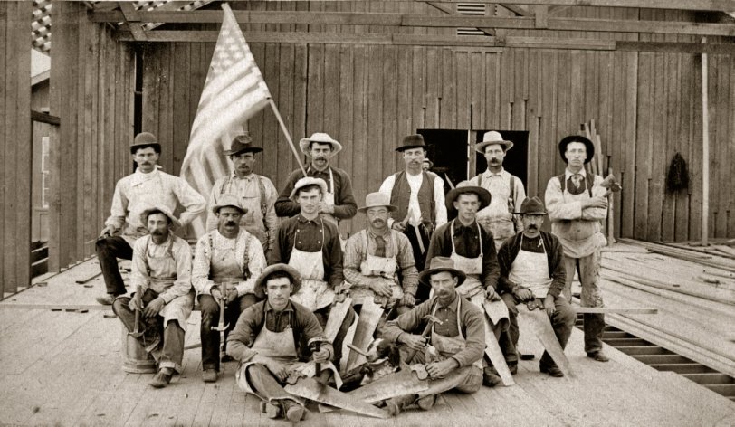 This family photo was taken on July 4th, 1887. My grandfather is seated on the floor at front left. That's his helpful dog next to him holding a hammer in its mouth. He was twenty years old in 1887, but he was already a contractor and this was his crew. The building they were constructing was the AT&amp;SF train station at San Dimas, California. View full size.
