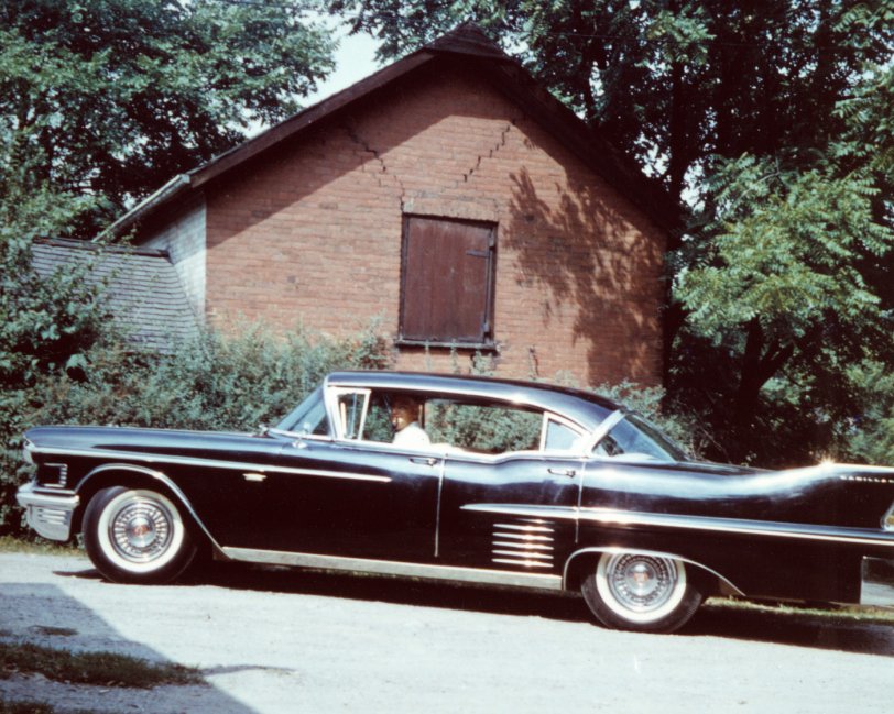 My uncle's '58 Cadillac - one of two identical - he had for his funeral director's business in Dundas, Ont. in the late 1950s. I was about 10 when this shot was taken in summer of 1960, with the backdrop being an early-1800s brick shed next door. 
As a car-crazy kid in the late 50s, I was awed that he had TWO identical '58 Caddys. I rode in both and couldn't tell them apart, but they were sure a big step up from my Dad's '56 Chev 210 4-dour 6-cylinder three-on-the-tree he had at the time. View full size.

