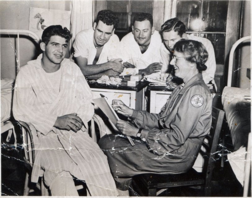 The note on the back says "Mrs. Conant &amp; the boys at the Chelsea Naval Hospital in Chelsea, Mass. Mrs. C. drawing a quick pencil sketch of a wounded Marine or sailor recuperating therein. -  from a letter postmarked Cambridge, Mass, [12]/ 11/44"
Mrs. Conant was a friend of my father's when he attended MIT before and after the war. I think this may be Grace T. Conant, wife of James Bryant Conant, then president of Harvard University. The one photo I can find, taken in 1953 of the Conants, resembles the woman in this photo. Mrs. Conant corresponded with my father during the war, while he was serving with the Canadian Army. View full size.
