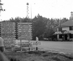 My grandfather sometime in the 50's took a camping trip from the Watertown area of Wisconsin into Michigan through Michigan's Upper Peninsula.  I'm trying to figure out where these were taken, if anyone lives near these areas would you mind taking some current photos and sending them my way. View full size.
That-a-wayEverything seems to be off to the right.
The Tower BarThe location of this image is 163 County Road W, Manitowish Waters, WI. The Tower Bar is now called Artist's Palette according to Google Street View. (Gives Google an affectionate pat)
View Larger Map
Tower Road - Tower BarAgreed that it is Manitowish, WI - near the Michigan border.  Attached is a map with a star at Winegar, WI and Winchester is not that far away.
BTW, all 3 of your photos say the trip was in the 1950s, yet I only see 1940s and earlier cars.
Was wrong about the dateAlong with the photos, Dad found a permission my great granddad had to sign for my granddad.  It was dated May 18, 1949
(ShorpyBlog, Member Gallery)