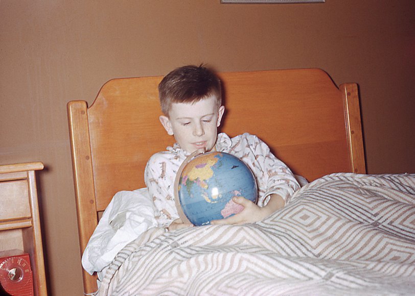 My father took this Kodachrome of me in 1956 in Riverside (now Windsor) Ontario. The tube radio was tuned to 1130 AM, WCAR in Pontiac, Michigan. Also visible on the dial are the Conelrad (Civil Defense) stations, at 640 and 1230 kHz. Every Saturday at noon we heard the air raid sirens being tested in Detroit, just across the river. The red opaque plastic glowed warmly in the dark. The fact that I am holding the globe with Australia in my hand was prophetic - within two years our family had moved there. My favourite song on the radio at this time: "Standing on the Corner" by the Four Lads.  View full size.
