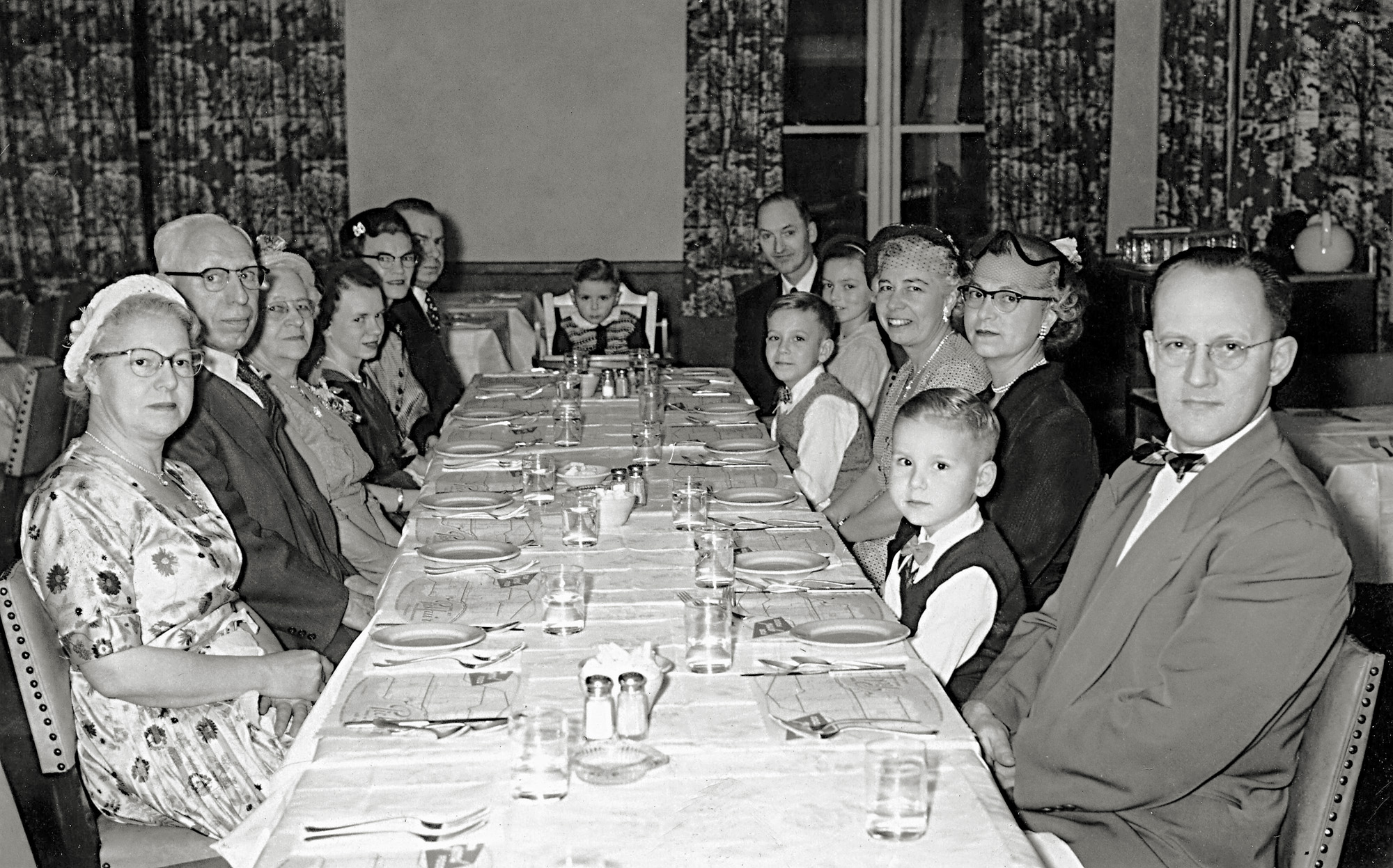 This shot of an extended-family special "dinner out" from 1953 was passed to me by my cousin recently (who is also in this picture), 65 years ago. I'm the high-chair scowling toddler at the far end of the table while my older brothers, parents, cousin, aunt and uncle are on the right. My maternal grandparents, aunts, uncle and cousin are on the left. An uncle took the shot (the funeral director uncle that impressed me as a car-crazed kid with his two 1958 black Cadillacs for his business, one of them seen here.

This was apparently a very special dinner out, as we almost never went out for meals as a kid or teenager. View full size.